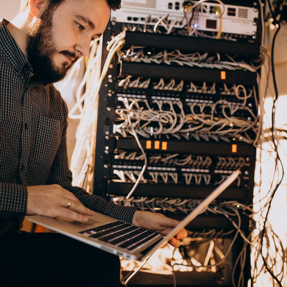 Mann aus der IT sitzt mit Laptop auf dem Schoss